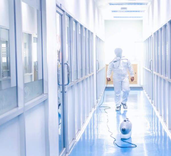 Person Walking in HazMat Suit Down a Hallway